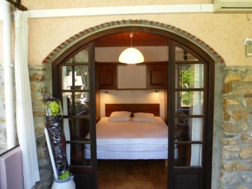 a bedroom with an arched doorway with a bed at Maisonette rustique- pinède piscine in Argelès-sur-Mer