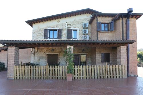 a house with a wooden fence in front of it at Agriturismo Podere S. Croce in Saturnia