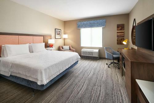 um quarto de hotel com uma cama e uma televisão de ecrã plano em Hampton Inn Clewiston em Clewiston