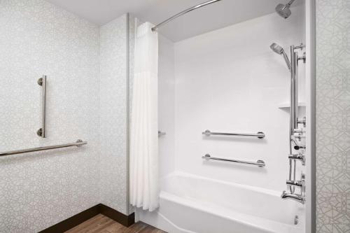 a white bathroom with a shower and a bath tub at Hampton Inn Clewiston in Clewiston