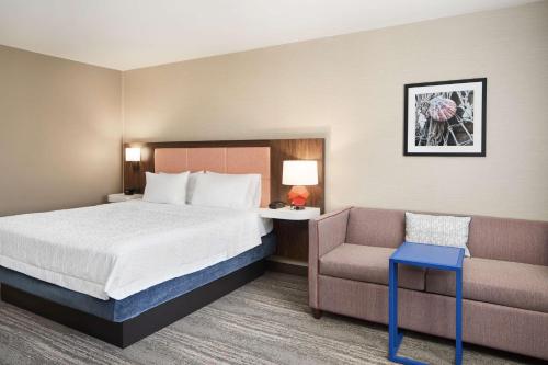 a hotel room with a bed and a chair at Hampton Inn Clewiston in Clewiston