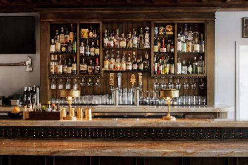a bar with a lot of bottles of alcohol at The Fin Hotel, Tapestry Collection by Hilton in Oceanside