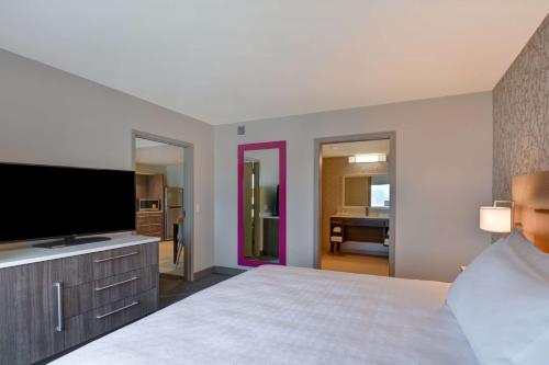 a bedroom with a bed and a flat screen tv at Home2 Suites Williston Burlington, Vt in Williston