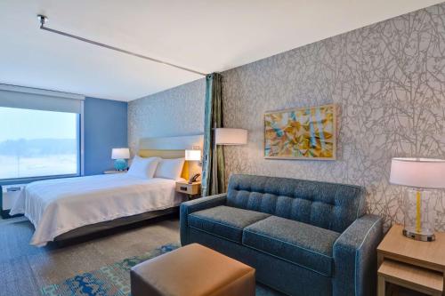 um quarto de hotel com uma cama e um sofá em Home2 Suites Williston Burlington, Vt em Williston