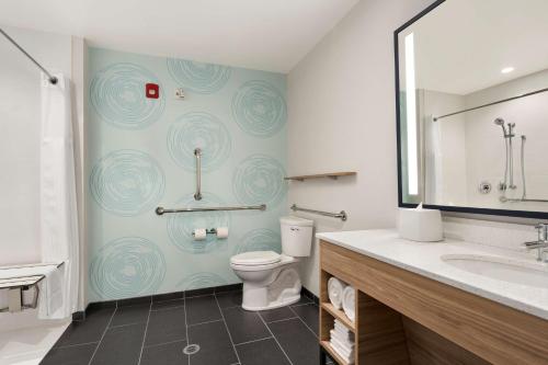uma casa de banho com um WC, um lavatório e um espelho. em Tru By Hilton Albany Airport, Ny em Latham