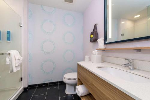 La salle de bains est pourvue de toilettes, d'un lavabo et d'un miroir. dans l'établissement Tru By Hilton Elkhart, In, à Elkhart