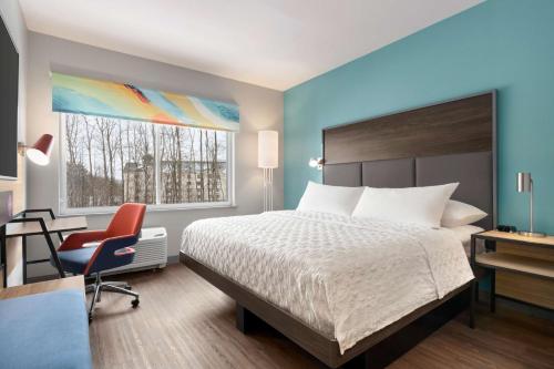 a bedroom with a bed and a desk and a chair at Tru By Hilton Albany Airport, Ny in Latham