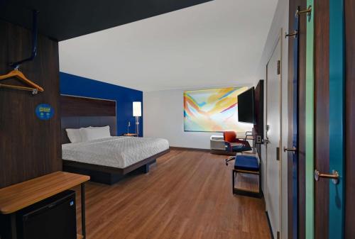 1 dormitorio con 1 cama y TV. en Tru By Hilton Monroe, MI, en Monroe
