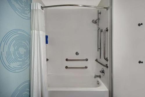 uma casa de banho com um chuveiro e uma banheira branca em Tru By Hilton Monroe, MI em Monroe