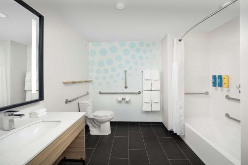 a bathroom with a toilet and a tub and a sink at Tru By Hilton Orlando Convention Center in Orlando