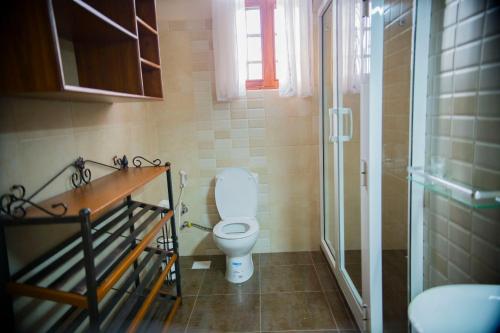 e bagno con servizi igienici e doccia in vetro. di Cornerstone Villas ad Arusha