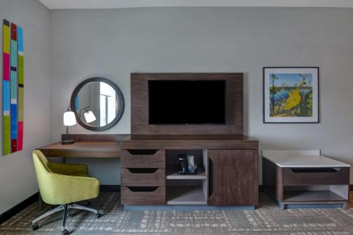 a room with a desk with a television and a mirror at Hampton Inn & Suites Tampa Riverview Brandon in Tampa
