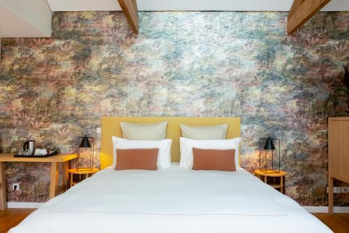Dormitorio con cama blanca y pared colorida en Villa Fabulite en Antibes