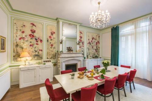 comedor con mesa, sillas y chimenea en "Le Jardin sur l'Eau "chambres d'hôtes et appartement tout confort, en Aire-sur-lʼAdour