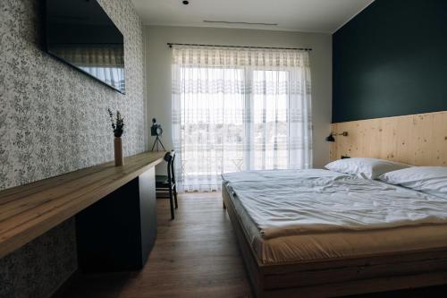 a bedroom with a bed and a large window at Postcard Country Apartments in Spodnji Duplek