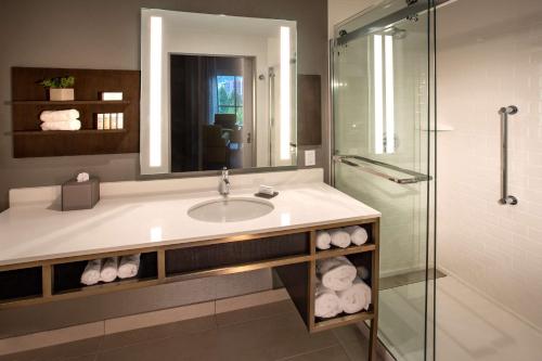 a bathroom with a sink and a glass shower at Hilton Garden Inn Redmond Town Center, Wa in Redmond