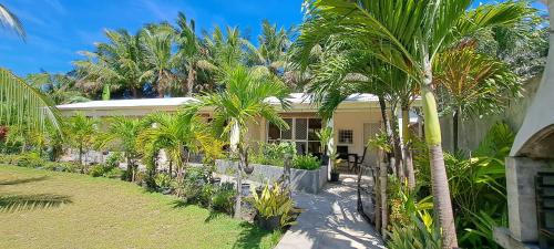 una casa con palme di fronte di Mirka's Guest House a Isola di Bantayan