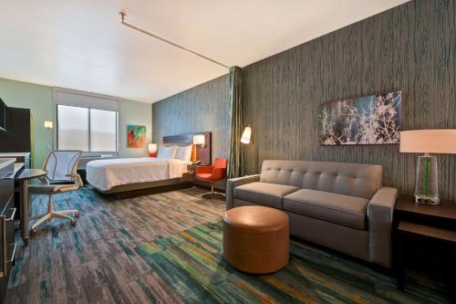 a hotel room with a bed and a couch at Home2 Suites By Hilton Atascadero, Ca in Atascadero