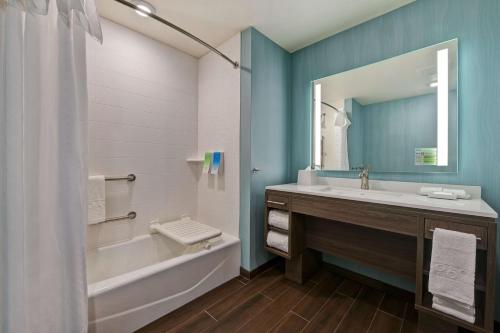 a bathroom with a tub and a sink and a mirror at Home2 Suites By Hilton Atascadero, Ca in Atascadero