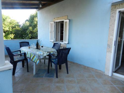 ein Tisch und Stühle auf einer Terrasse in der Unterkunft Apartment Deni in Lumbarda