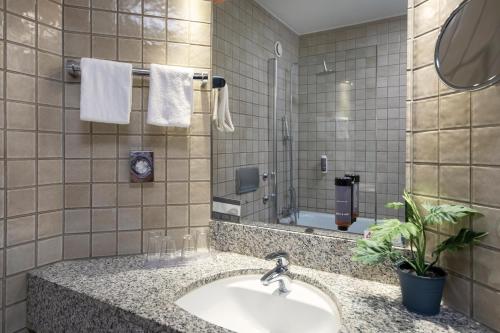 a bathroom with a sink and a mirror at ACHAT Hotel Kaiserhof Landshut in Landshut