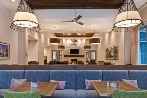 a dining room with a blue couch and tables at Homewood Suites By Hilton Summerville in Summerville