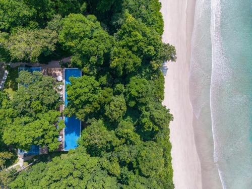 an overhead view of a house in the trees next to a beach at Taj Exotica Resort & Spa, Andamans in Havelock Island