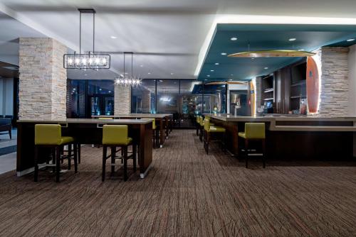 a restaurant with tables and chairs and a bar at SunCoast Hotel Anaheim, Tapestry Collection by Hilton in Anaheim
