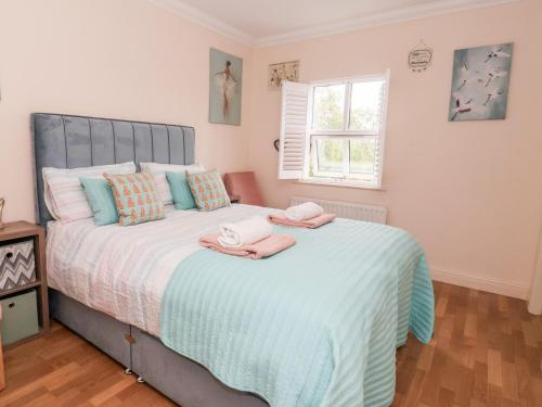 a bedroom with a large bed with towels on it at 1 Cockerill Fold in Beverley