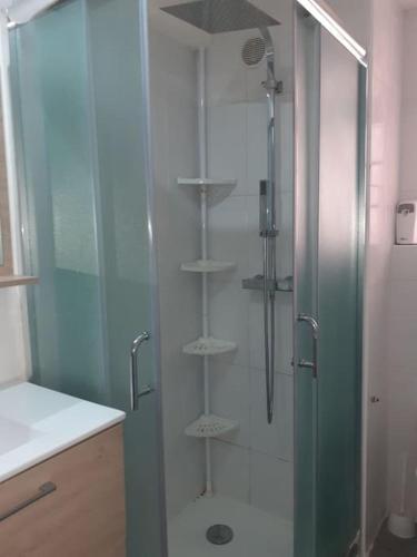 une douche avec une porte vitrée dans une salle de bain dans l'établissement Jolie 2P au centre de golfe-juan à 2mn des plages, à Vallauris