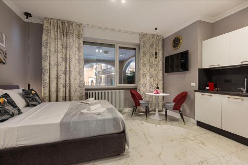 a bedroom with a bed and a table with chairs at Emerald Suites in Stresa