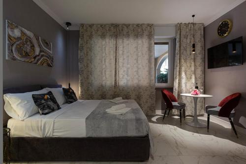 a bedroom with a bed and a table and chairs at Emerald Suites in Stresa