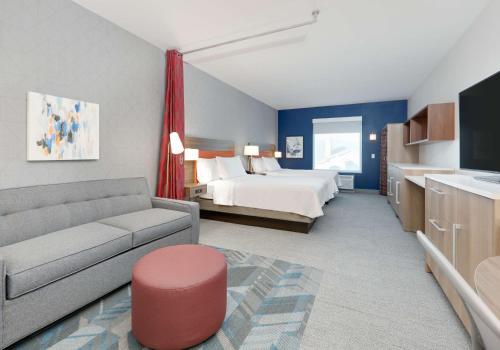 a hotel room with a bed and a couch at Home2 Suites By Hilton Euless Dfw West, Tx in Euless