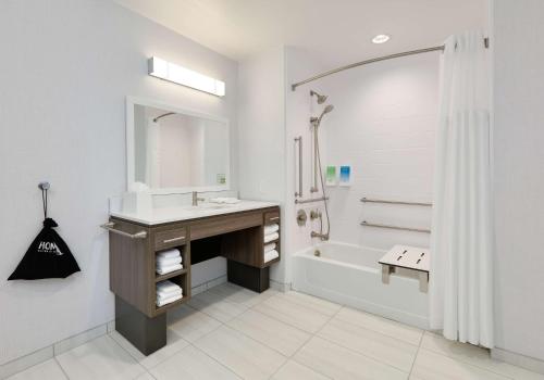 a white bathroom with a sink and a bath tub at Home2 Suites By Hilton Euless Dfw West, Tx in Euless