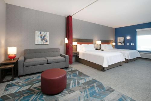 a hotel room with a bed and a couch at Home2 Suites By Hilton Euless Dfw West, Tx in Euless