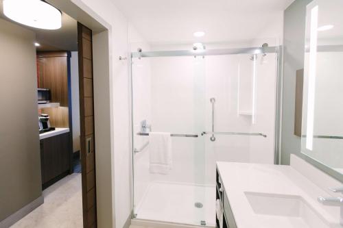 a bathroom with a shower with a glass door at Hilton Garden Inn Winter Park, FL in Orlando