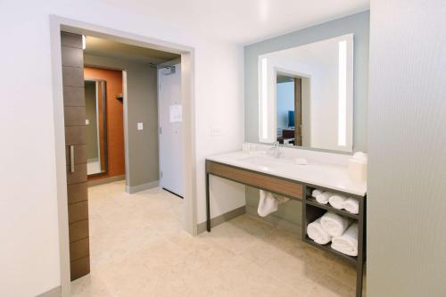 Hilton Garden Inn Winter Park, FL في أورلاندو: حمام مع حوض ومرآة