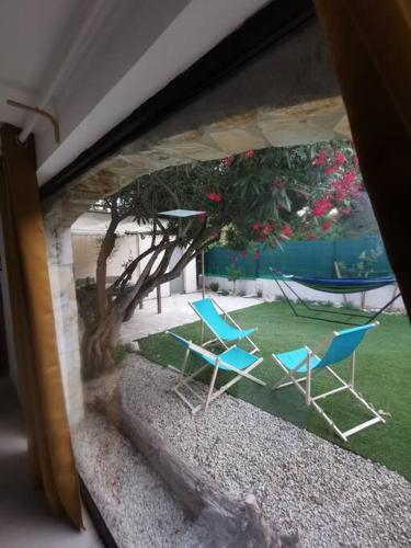 2 chaises bleues et un arbre dans la cour dans l'établissement Superbe T3 Bord de mer, à Sausset-les-Pins