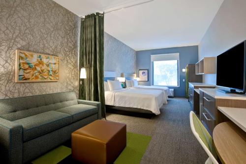 Habitación de hotel con cama y sofá en Home2 Suites By Hilton Lewisville Dallas, en Lewisville