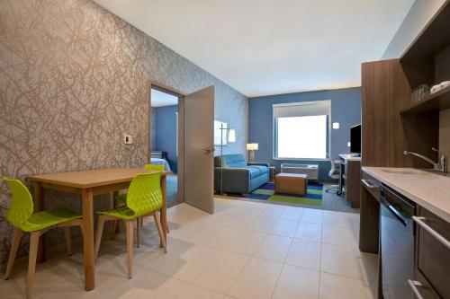a kitchen and living room with a table and chairs at Home2 Suites By Hilton Lewisville Dallas in Lewisville
