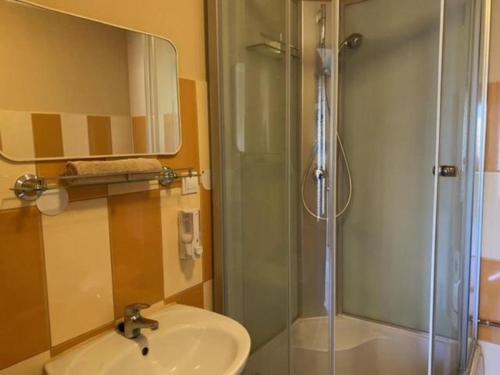 ポロスローにあるPipacs Vendégházのバスルーム(洗面台、ガラス張りのシャワー付)