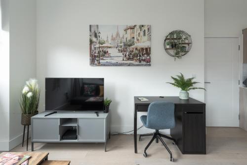 an office with a desk and a tv and a chair at Deluxe 2 bed, 2 bathroom Milton Keynes apartment within walking distance to train station and City centre. in Milton Keynes