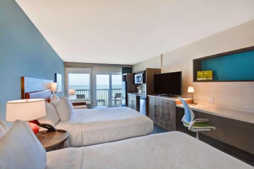 Habitación de hotel con 2 camas y TV de pantalla plana. en Home2 Suites Ormond Beach Oceanfront, FL, en Ormond Beach