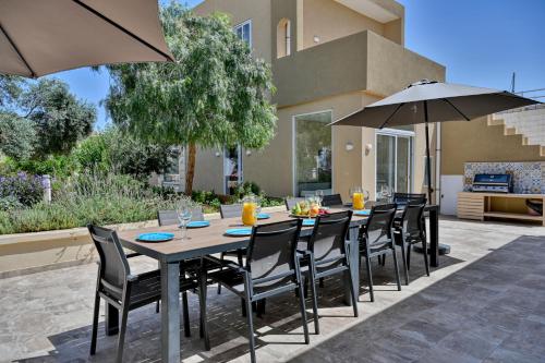 una mesa y sillas con sombrillas en el patio en Ta Benna Villa, en Għajnsielem