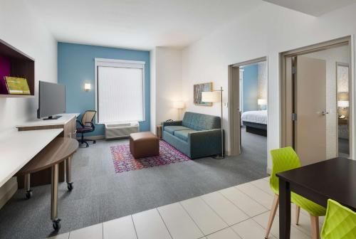 a hotel room with a couch and a bed and a desk at Home2 Suites By Hilton Stuart in Stuart