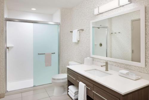 a bathroom with a sink and a toilet and a mirror at Home2 Suites By Hilton Stuart in Stuart
