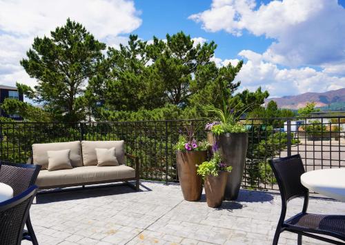a patio with a couch and some chairs and a fence at Hampton Inn Colorado Springs I-25 Central in Colorado Springs