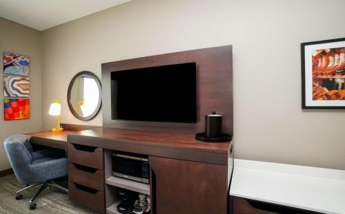 a room with a television and a desk with a chair at Hampton Inn Colorado Springs I-25 Central in Colorado Springs