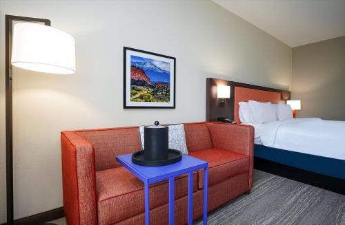 コロラドスプリングスにあるHampton Inn Colorado Springs I-25 Centralのソファとベッド付きのホテルルーム