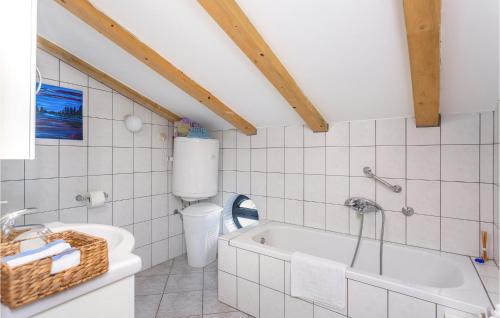 a bathroom with a toilet and a bath tub at Beautiful Home In Krk With 2 Bedrooms, Wifi And Outdoor Swimming Pool in Garica